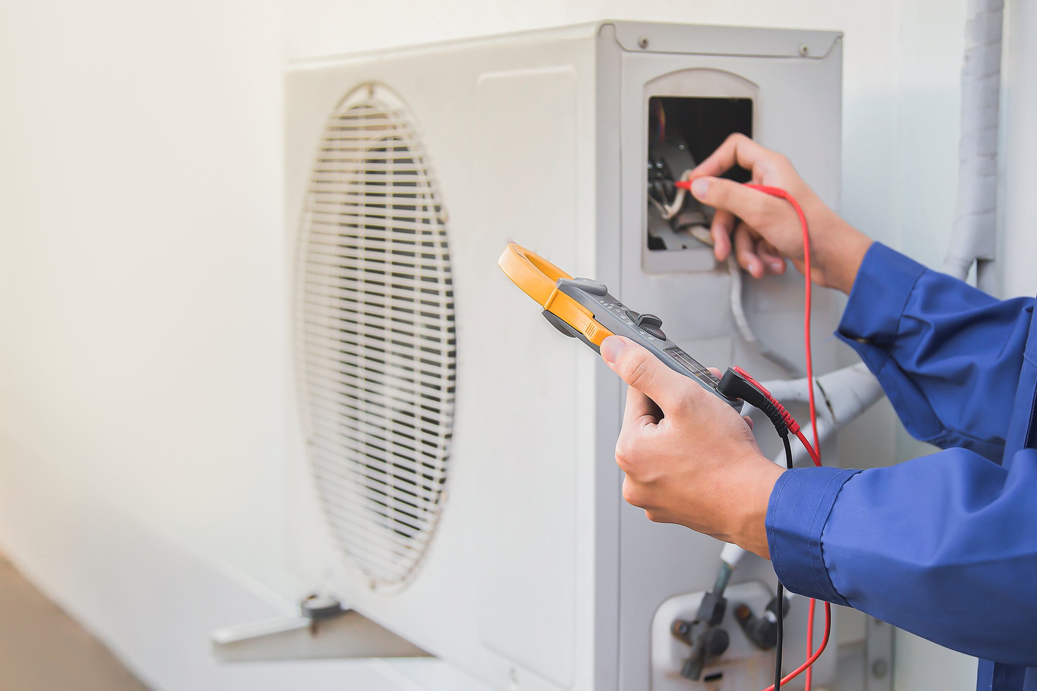 Air conditioning, HVAC service technician using gauges to check refrigerant and add refrigerant.